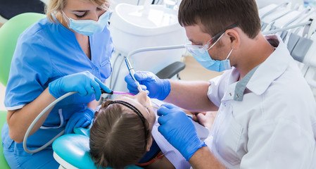 Auxiliar em Saúde Bucal ajudando o dentista durante atendimento a paciente